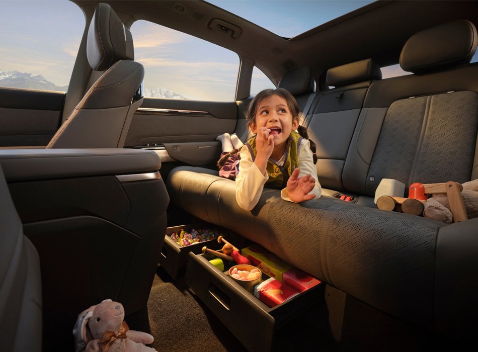 A young girl eating snacks laying in the back of a Zeekr EV