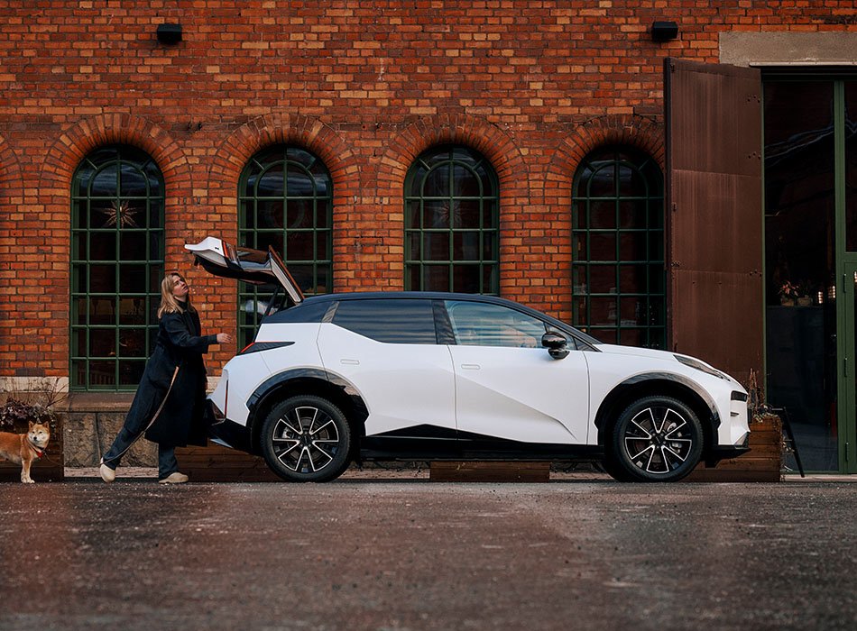 A woman packing the boot a white Zeekr X SUV infront of a brick building