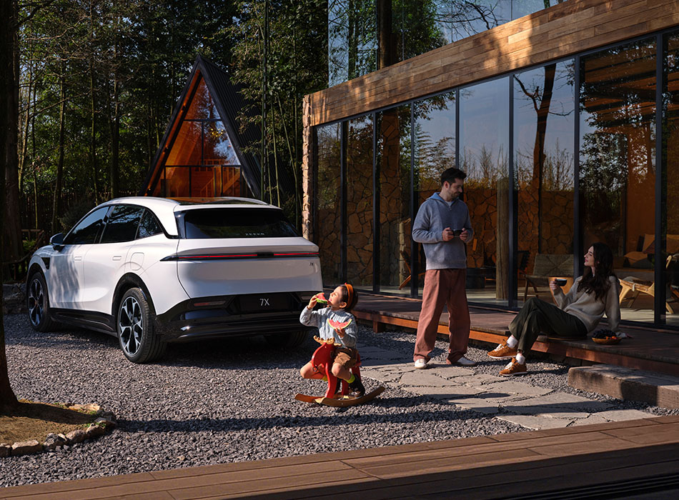 Rear angle of a white Zeekr SUV with a family outside of a cabin